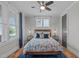 Cozy bedroom with a comfortable bed, ceiling fan, and natural light at 109 Big Timber Path, Holly Springs, NC 27540