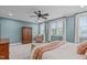 Spacious bedroom featuring neutral carpet, a ceiling fan, and multiple windows at 109 Big Timber Path, Holly Springs, NC 27540