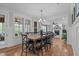 Bright dining area boasts modern chandelier, wood floors, and direct view into living room with fireplace at 109 Big Timber Path, Holly Springs, NC 27540