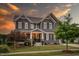 Two-story home featuring gray siding, a covered front porch with stone accents, and a manicured front yard at 109 Big Timber Path, Holly Springs, NC 27540