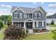 Charming two-story home with gray siding, landscaped yard, and a welcoming front porch at 109 Big Timber Path, Holly Springs, NC 27540