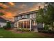 Back exterior showcasing a screened-in porch, outdoor patio area, well-maintained lawn and gray siding at 109 Big Timber Path, Holly Springs, NC 27540