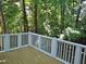 A spacious wood deck with white railings offers a tranquil outdoor space surrounded by lush greenery and trees at 1104 Barrow Nook Ct, Apex, NC 27502