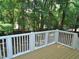 Back deck with brown floorboards and white railing overlooking trees in a private backyard at 1104 Barrow Nook Ct, Apex, NC 27502