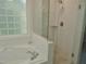 Bright bathroom features a luxurious tub and a glass-enclosed shower with stylish tile work at 1104 Barrow Nook Ct, Apex, NC 27502
