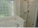 Bright bathroom features a luxurious tub and a glass-enclosed shower with stylish tile work at 1104 Barrow Nook Ct, Apex, NC 27502