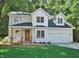 Charming two-story home featuring a covered porch, a two-car garage, and lush green lawn at 1104 Barrow Nook Ct, Apex, NC 27502