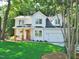 Charming two-story home featuring a covered porch, a two-car garage, and lush green lawn at 1104 Barrow Nook Ct, Apex, NC 27502