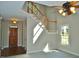 Inviting foyer featuring a wood door, stairway with wooden handrail, and a light-filled entry for a warm welcome at 1104 Barrow Nook Ct, Apex, NC 27502