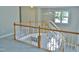 Hallway with a wooden banister, neutral walls and carpet, and natural light streaming in through several windows at 1104 Barrow Nook Ct, Apex, NC 27502