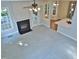 Cozy living room featuring a fireplace, ceiling fan, and abundant light from windows, flowing into the dining area at 1104 Barrow Nook Ct, Apex, NC 27502