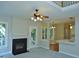 Cozy living room with a fireplace, ceiling fan, and doorway to kitchen at 1104 Barrow Nook Ct, Apex, NC 27502