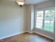 Bright room featuring hardwood floors, neutral paint, and a large window at 1104 Barrow Nook Ct, Apex, NC 27502