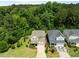 Enjoy this aerial view of the home nestled among trees and featuring a manicured lawn and driveway at 111 Chapel Run Way, Chapel Hill, NC 27517