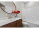 Stylish bathroom with a modern sink, wooden cabinets, a decorative mirror, and a shower-tub combo at 111 Chapel Run Way, Chapel Hill, NC 27517