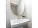 Modern pedestal sink with brushed silver faucet and decorative mirror in well-lit, contemporary half-bathroom at 111 Chapel Run Way, Chapel Hill, NC 27517