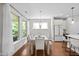 Bright dining room with modern table near large windows and an open view to the modern kitchen at 111 Chapel Run Way, Chapel Hill, NC 27517