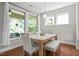 Bright dining room featuring a modern table, bench seating, and large windows overlooking a screened-in porch at 111 Chapel Run Way, Chapel Hill, NC 27517