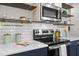 Close up of modern kitchen features stainless steel appliances, subway tile backsplash and open shelving at 111 Chapel Run Way, Chapel Hill, NC 27517
