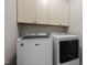 Bright laundry room featuring a white Maytag washer and dryer, paired with storage cabinets at 111 Chapel Run Way, Chapel Hill, NC 27517