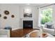Cozy living room with a fireplace, neutral-toned furniture, and a large window offering natural light at 111 Chapel Run Way, Chapel Hill, NC 27517