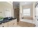 A full bathroom with double vanity, glass shower, and soaking tub awaits in this spacious home at 111 Streamside Dr, Sanford, NC 27330