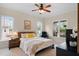 A bright bedroom features a ceiling fan, neutral paint, and lots of natural light from the large windows at 111 Streamside Dr, Sanford, NC 27330