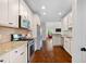 Modern kitchen with granite countertops, stainless steel appliances, and abundant white cabinetry and a living room view at 111 Streamside Dr, Sanford, NC 27330