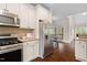 Well-equipped kitchen features stainless steel appliances, granite counters, and a pass-through to the outdoor living area at 111 Streamside Dr, Sanford, NC 27330