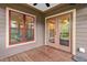 Outdoor porch featuring red trim, and view to the interior through glass paneled doors at 111 Streamside Dr, Sanford, NC 27330