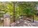 Outdoor deck with a grill and patio set, surrounded by trees for a private backyard space at 112 Fairford Dr, Holly Springs, NC 27540
