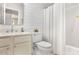 Well-lit bathroom featuring a white vanity, toilet, and shower/tub combo with a white shower curtain at 112 Fairford Dr, Holly Springs, NC 27540