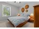 Cozy bedroom features a large window, ceiling fan, and comfortable queen-size bed with patterned bedding at 112 Fairford Dr, Holly Springs, NC 27540
