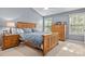 Spacious bedroom with a wooden bed frame, matching dresser, and ample natural light at 112 Fairford Dr, Holly Springs, NC 27540