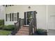 Inviting front entrance featuring brick steps, dark wood railings, and manicured landscaping at 112 Fairford Dr, Holly Springs, NC 27540