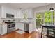 Bright kitchen features stainless appliances, granite counters, and access to a deck at 112 Fairford Dr, Holly Springs, NC 27540
