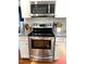 Stainless steel range with microwave, granite counters and white subway tile backsplash at 112 Fairford Dr, Holly Springs, NC 27540