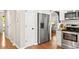 View of the stainless refrigerator in the kitchen, with white cabinets and hardwood floors at 112 Fairford Dr, Holly Springs, NC 27540