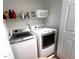 Efficient laundry area equipped with a white washer and dryer, and a shelf for storage at 112 Fairford Dr, Holly Springs, NC 27540