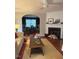 Bright living room showcasing a cozy fireplace, modern ceiling fan, and views into the dining area at 112 Fairford Dr, Holly Springs, NC 27540