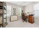 Home office with a leather chair, wooden desk, shelving, and natural light from multiple windows at 112 Fairford Dr, Holly Springs, NC 27540