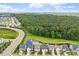 Aerial view showcases homes in a neighborhood surrounded by lush greenery, pond, and open skies at 113 Mazarin Ln, Cary, NC 27519