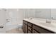Bathroom featuring double sinks, a tile shower-tub, and a modern design with wood cabinets at 113 Mazarin Ln, Cary, NC 27519