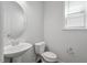 Powder room featuring pedestal sink, oval mirror, toilet, and small window at 113 Mazarin Ln, Cary, NC 27519