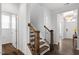 Traditional staircase leading to entryway with a white front door, and a chandelier in the background at 113 Mazarin Ln, Cary, NC 27519