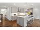 Stylish kitchen featuring a gray center island with granite countertops, stainless steel appliances, and hardwood floors at 113 Mazarin Ln, Cary, NC 27519