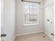 Well-lit laundry room with window, tile flooring, and convenient shelving for storage at 113 Mazarin Ln, Cary, NC 27519