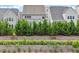 Pond view featuring gray homes and a retaining wall with bushes at 113 Mazarin Ln, Cary, NC 27519