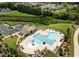 Community pool area with lounge chairs, tables, and ample seating near a clubhouse and parking area at 113 Mazarin Ln, Cary, NC 27519