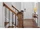 Traditional staircase with oak wood banister and black metal spindles, leads to a white door at 113 Mazarin Ln, Cary, NC 27519